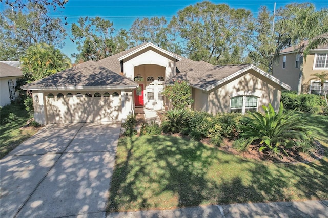 view of front of property with a front yard and a garage