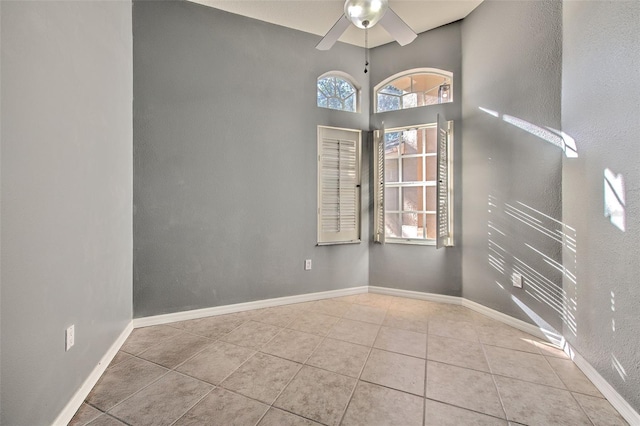 spare room with ceiling fan and light tile patterned flooring