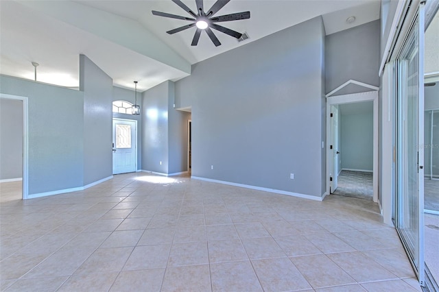 tiled empty room featuring ceiling fan and high vaulted ceiling