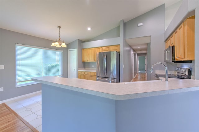 kitchen with a chandelier, light hardwood / wood-style floors, vaulted ceiling, and appliances with stainless steel finishes