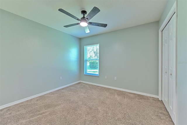 unfurnished bedroom featuring light carpet, a closet, and ceiling fan