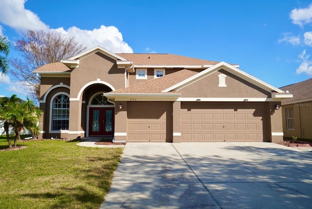 view of front of house featuring french doors, a front yard, and a garage