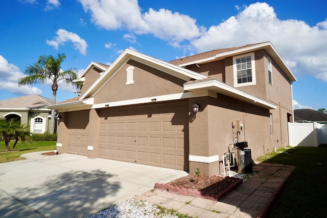 2012 Fern Ridge Ct, Holiday, FL 34691 - view of home's exterior featuring stucco siding, a garage, and concrete driveway