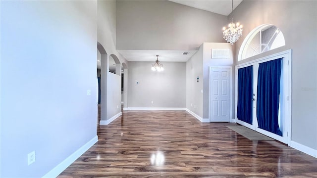 2012 Fern Ridge Ct, Holiday, FL 34691 - entrance foyer with a chandelier, a high ceiling, baseboards, wood finished floors, and arched walkways