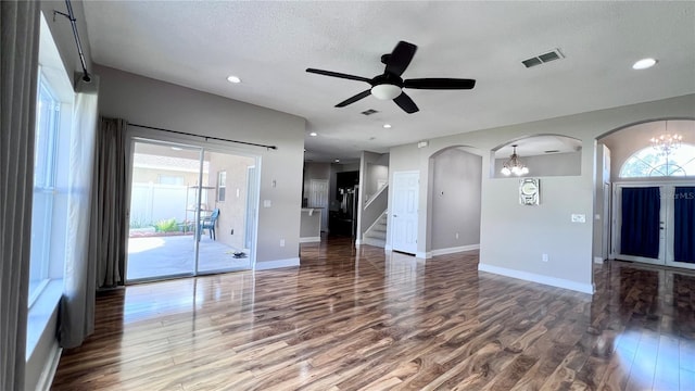 2012 Fern Ridge Ct, Holiday, FL 34691 - unfurnished living room featuring wood finished floors, arched walkways, baseboards, ceiling fan, and stairway