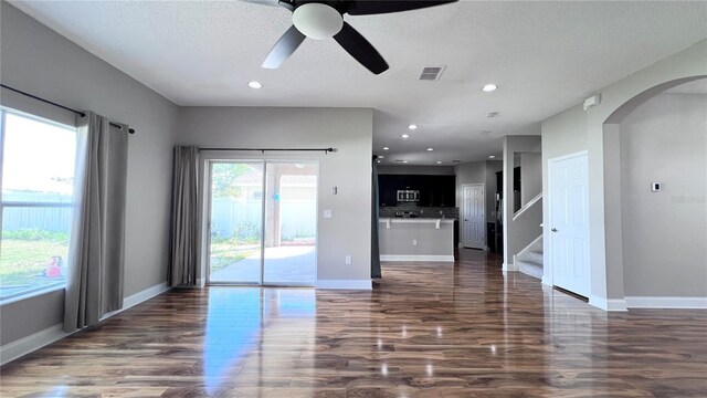 2012 Fern Ridge Ct, Holiday, FL 34691 - empty room featuring arched walkways, a ceiling fan, stairway, dark wood-style flooring, and baseboards