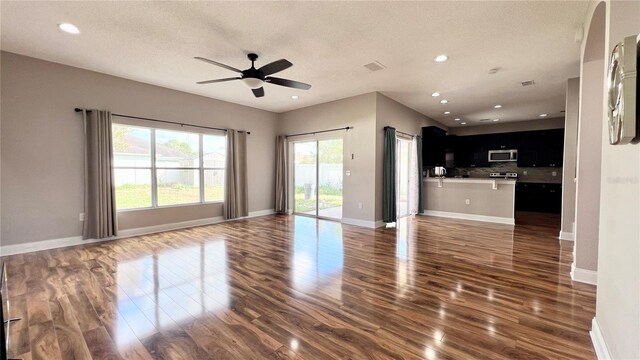 2012 Fern Ridge Ct, Holiday, FL 34691 - unfurnished living room with wood finished floors, a ceiling fan, recessed lighting, baseboards, and a textured ceiling