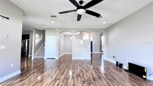 2012 Fern Ridge Ct, Holiday, FL 34691 - unfurnished living room featuring arched walkways, wood finished floors, ceiling fan, baseboards, and stairs