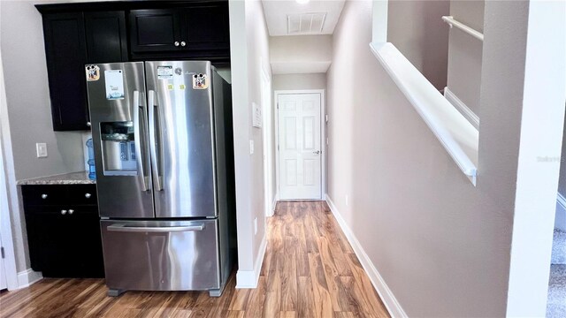 2012 Fern Ridge Ct, Holiday, FL 34691 - kitchen featuring stainless steel fridge, dark cabinetry, light wood-style floors, and baseboards
