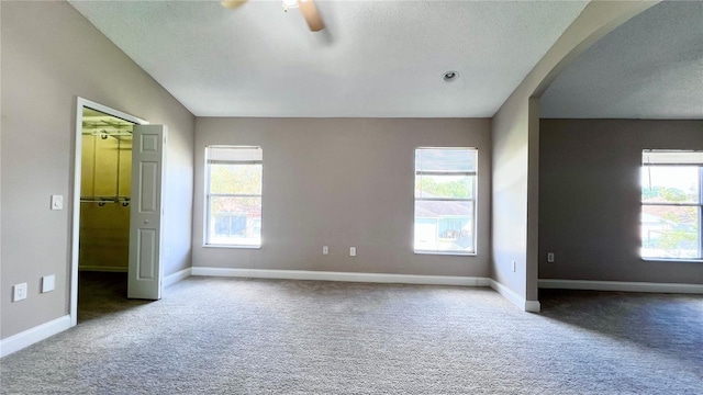 2012 Fern Ridge Ct, Holiday, FL 34691 - unfurnished bedroom with carpet flooring, a textured ceiling, baseboards, and arched walkways