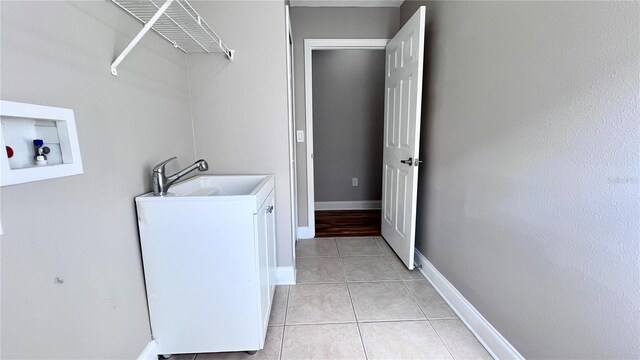 2012 Fern Ridge Ct, Holiday, FL 34691 - washroom featuring washer hookup, cabinet space, light tile patterned flooring, and baseboards