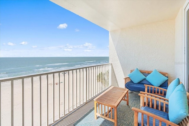 balcony featuring a beach view and a water view