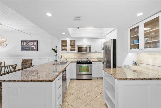 kitchen featuring white cabinetry, light stone countertops, kitchen peninsula, and appliances with stainless steel finishes