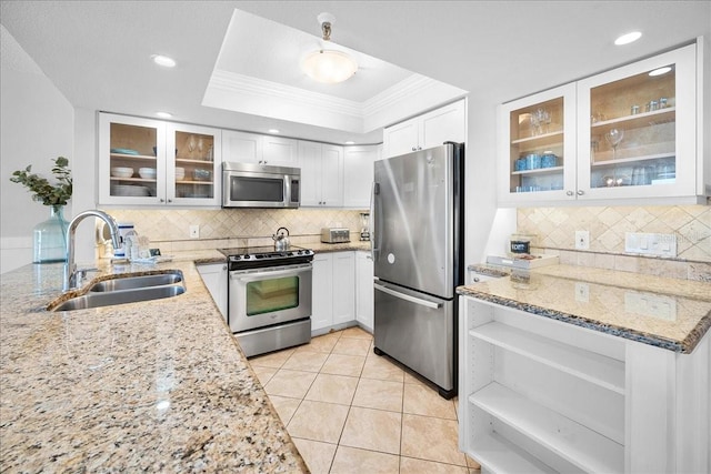 kitchen featuring light stone countertops, sink, stainless steel appliances, backsplash, and white cabinets