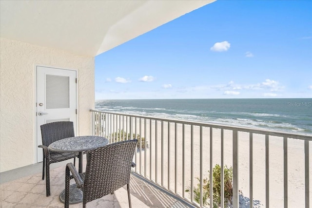 balcony featuring a water view and a beach view