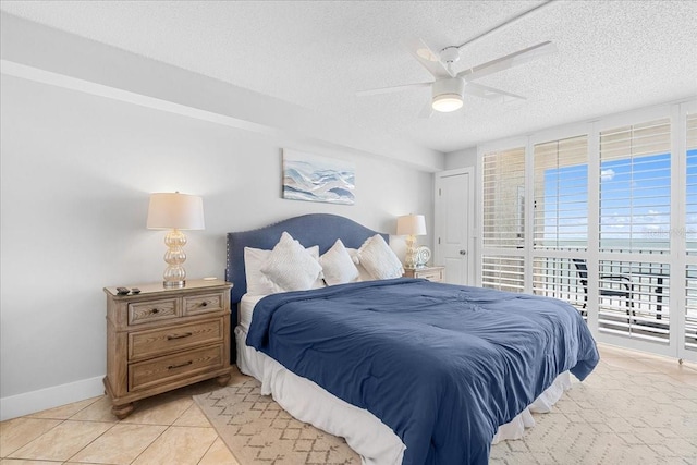 bedroom with multiple windows, light tile patterned floors, a textured ceiling, and ceiling fan