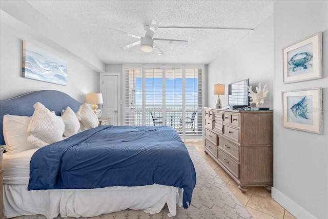 bedroom featuring light tile patterned floors, a textured ceiling, and ceiling fan