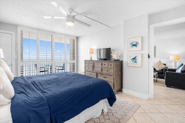 tiled bedroom with ceiling fan and a textured ceiling