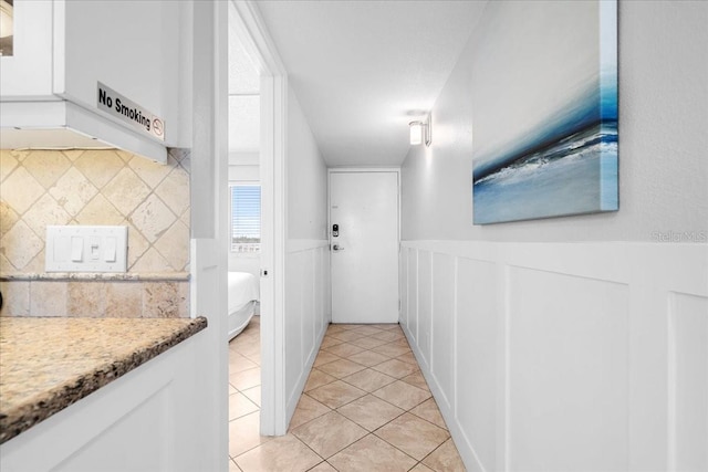 kitchen with white cabinets, decorative backsplash, and light tile patterned floors