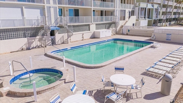 view of swimming pool featuring a patio area and a community hot tub