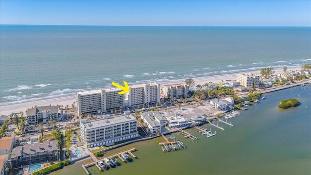 birds eye view of property with a water view and a beach view