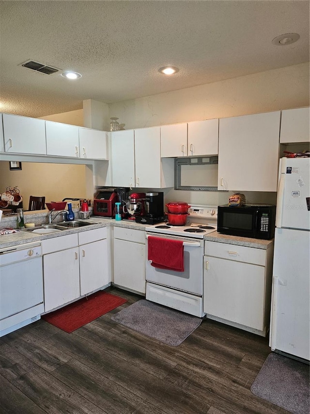 1252 Costa Mesa Dr, Wesley Chapel, FL 33543 - kitchen with white appliances, dark wood-style flooring, white cabinets, light countertops, and recessed lighting