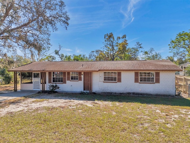 ranch-style home featuring a front yard and a carport