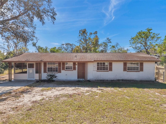 single story home featuring a front lawn and a carport