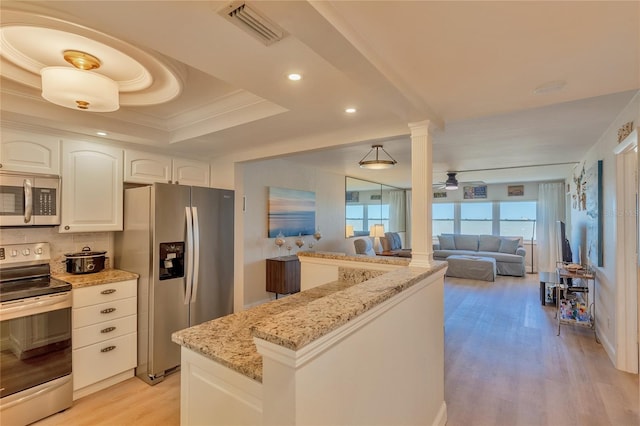 kitchen with light stone countertops, white cabinets, light hardwood / wood-style floors, and appliances with stainless steel finishes