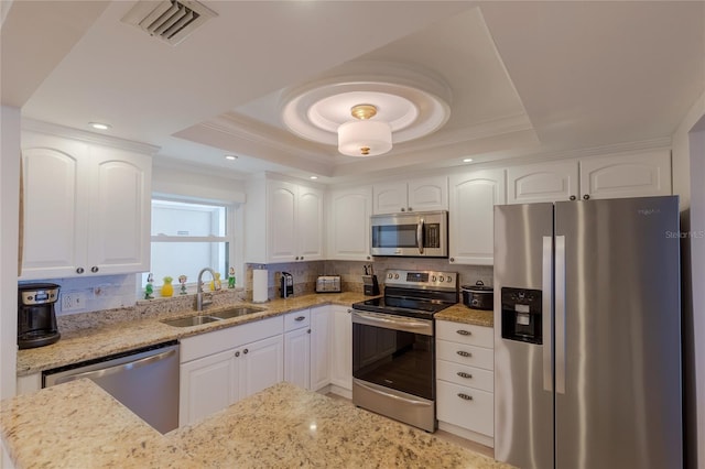 kitchen featuring white cabinets, a raised ceiling, sink, and stainless steel appliances