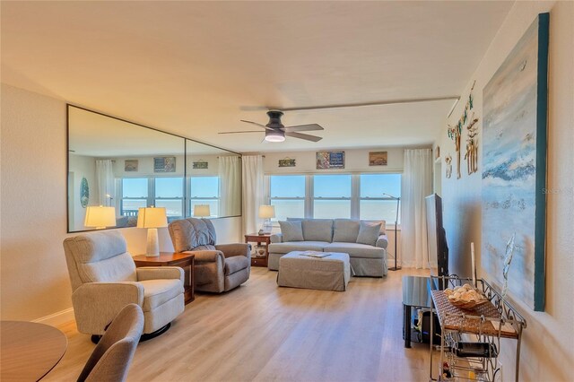 living room featuring light hardwood / wood-style flooring and ceiling fan