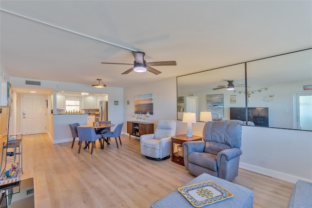 living room with ceiling fan and light hardwood / wood-style floors