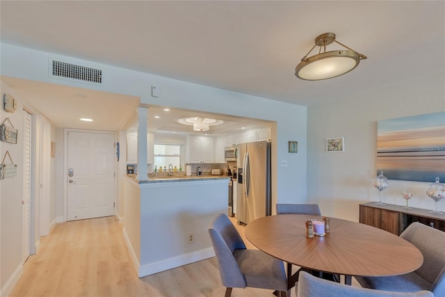 dining area with light hardwood / wood-style floors and sink