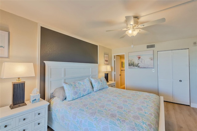 bedroom featuring a closet, light hardwood / wood-style floors, and ceiling fan