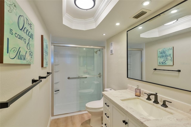 bathroom featuring toilet, wood-type flooring, a shower with shower door, and ornamental molding