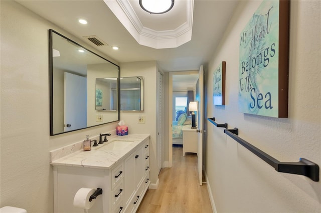 bathroom featuring hardwood / wood-style floors, vanity, and ornamental molding