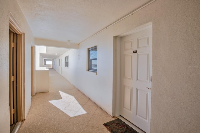 hall with a textured ceiling