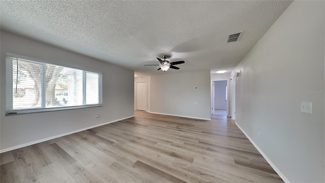 unfurnished room featuring ceiling fan, light hardwood / wood-style floors, and a textured ceiling