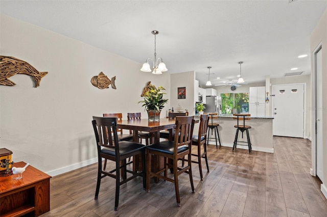 dining space with a chandelier and hardwood / wood-style floors