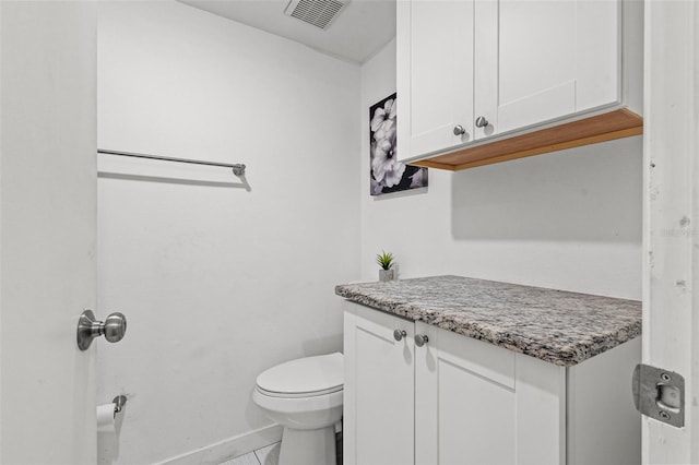 bathroom with tile patterned flooring, vanity, and toilet