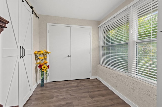 entryway with a barn door and dark hardwood / wood-style floors