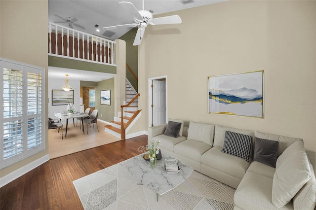 living room with a high ceiling, hardwood / wood-style flooring, and a healthy amount of sunlight