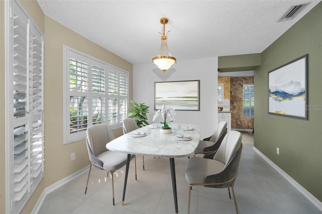 tiled dining area with a textured ceiling