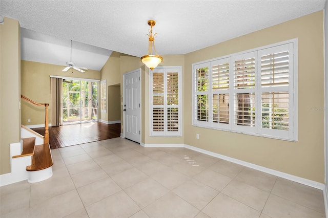 spare room with ceiling fan, light hardwood / wood-style floors, a textured ceiling, and vaulted ceiling