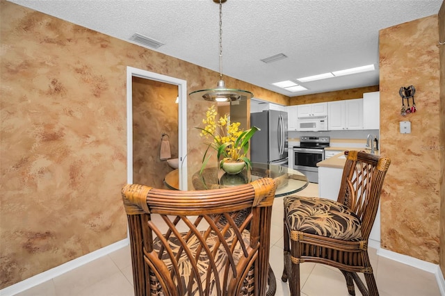 dining room with light tile patterned floors, a textured ceiling, and sink