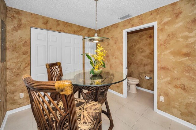 tiled dining space with a textured ceiling