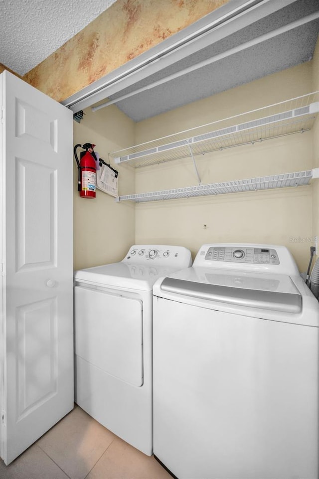 washroom featuring separate washer and dryer and a textured ceiling