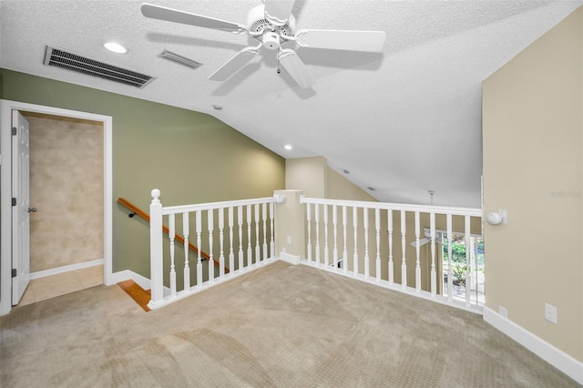 interior space with carpet, a textured ceiling, and vaulted ceiling