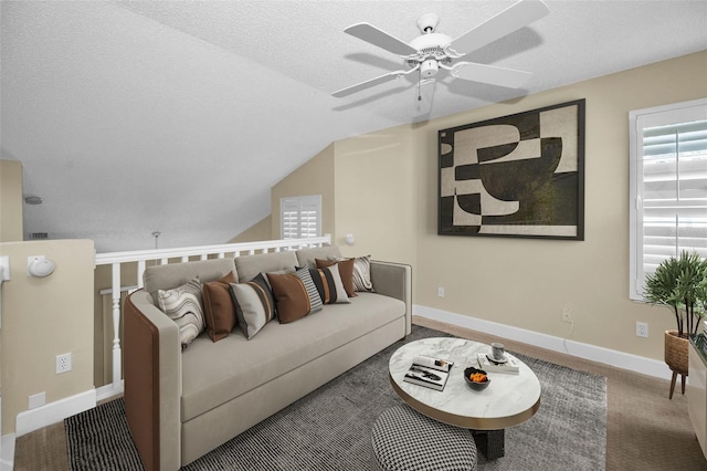 living room with a textured ceiling, carpet floors, vaulted ceiling, and ceiling fan