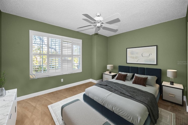 carpeted bedroom with ceiling fan and a textured ceiling